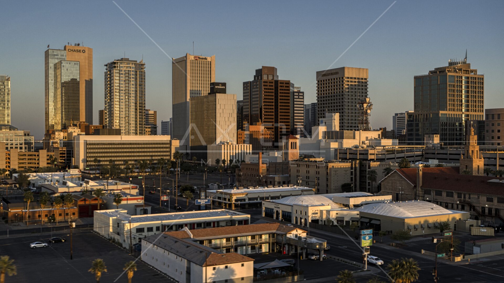 Aerial stock photo of the city's tall skyline at sunset with sunlight shining off the buildings; Downtown Phoenix, Arizona
